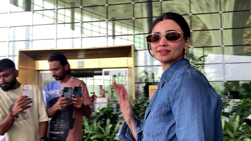 Daisy Shah spotted at Mumbai airport in casual chic outfit with denim jacket and white tee, carrying black leather bag and sunglasses