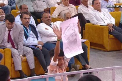 भवनगर रैली में प्रधानमंत्री नरेंद्र मोदी बच्चे की पेंटिंग लेते हुए, बच्चा भावुक, जनता तालियां बजाती हुई।