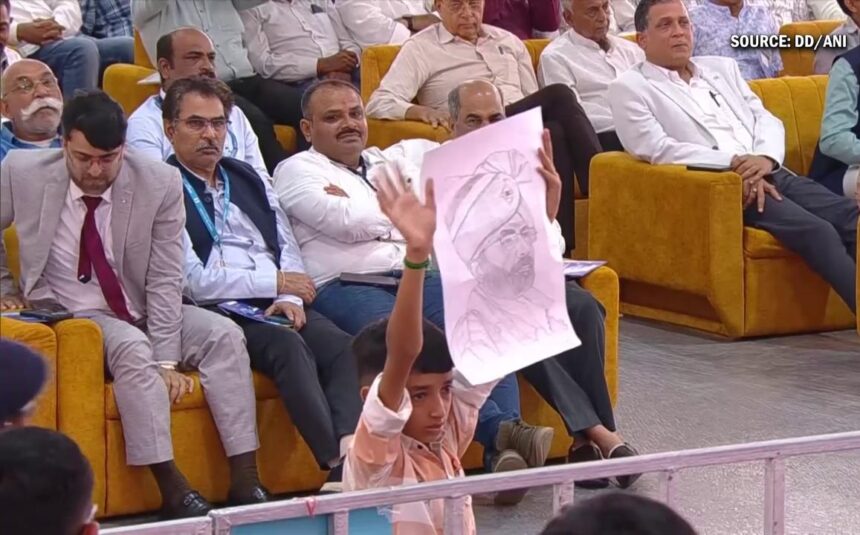 भवनगर रैली में प्रधानमंत्री नरेंद्र मोदी बच्चे की पेंटिंग लेते हुए, बच्चा भावुक, जनता तालियां बजाती हुई।