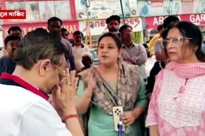 मेरठ के शास्त्री नगर में धरने पर बैठी महिला दुकानदारों के सामने हाथ जोड़ते हुए BJP नेता विनीत शारदा — जनता का दर्द और सत्ता की संवेदनहीनता का दृश्य।