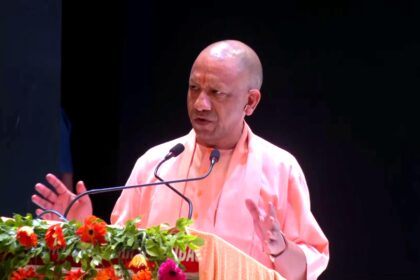 Uttar Pradesh Chief Minister Yogi Adityanath lighting a ceremonial lamp at the 'Deepotsav Se Rashtrotsav' program in Gorakhpur, surrounded by devotees and RSS members.