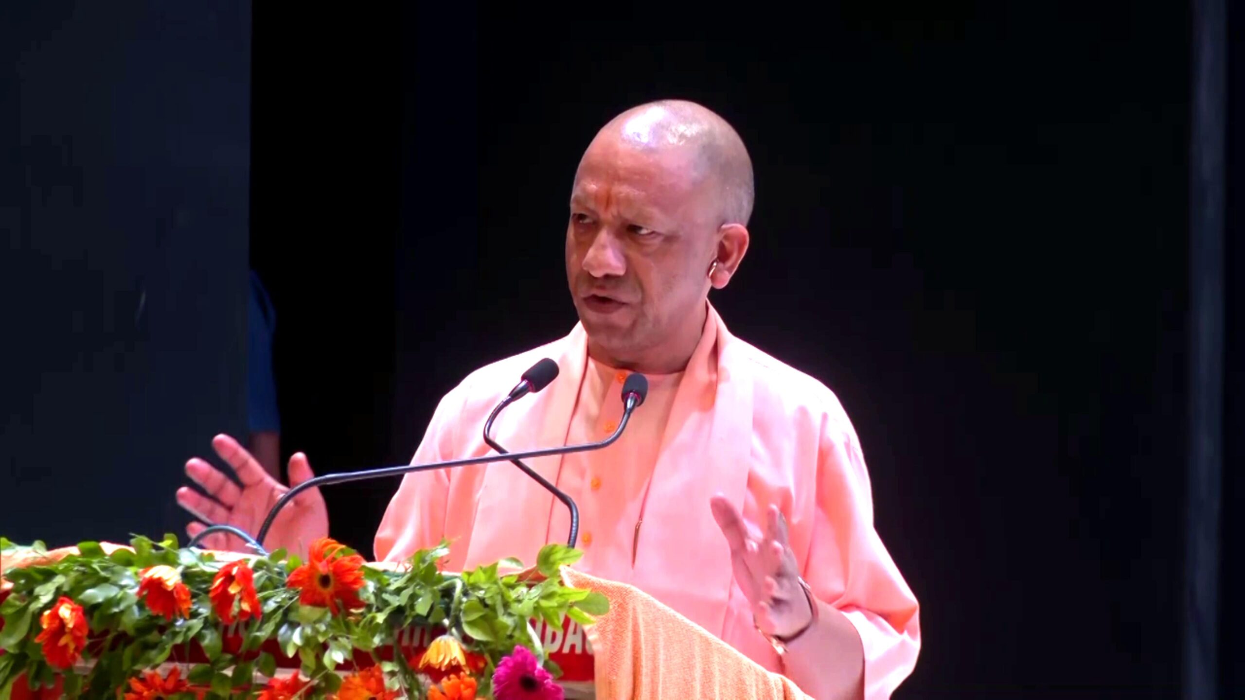 Uttar Pradesh Chief Minister Yogi Adityanath lighting a ceremonial lamp at the 'Deepotsav Se Rashtrotsav' program in Gorakhpur, surrounded by devotees and RSS members.