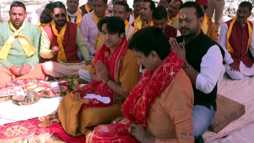 Dhirendra Krishna Shastri performing Yamuna Aarti at Barkot in Uttarkashi, surrounded by devotees on the serene riverbank of Yamuna.