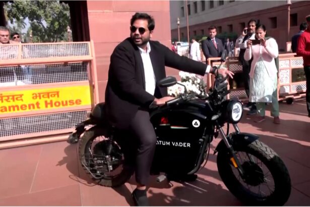 Congress leader Vamsi Gaddam arrives at Parliament on an electric bike during the Winter Session, highlighting pollution and environmental concerns.