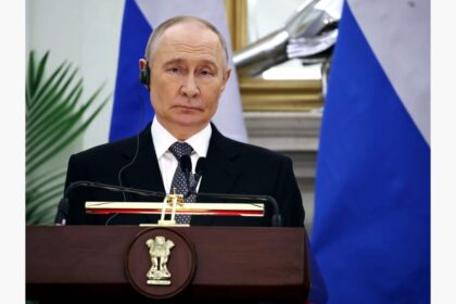 Russian President Vladimir Putin poses for a group photo with Delhi hotel staff during his India Visit 2025, showing a warm and friendly gesture.