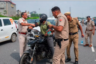 Gurugram traffic challan: गुरुग्राम सेक्टर 4/7 चौक पर ट्रैफिक पुलिस द्वारा जब्त की गई बाइक की जांच करते अधिकारी