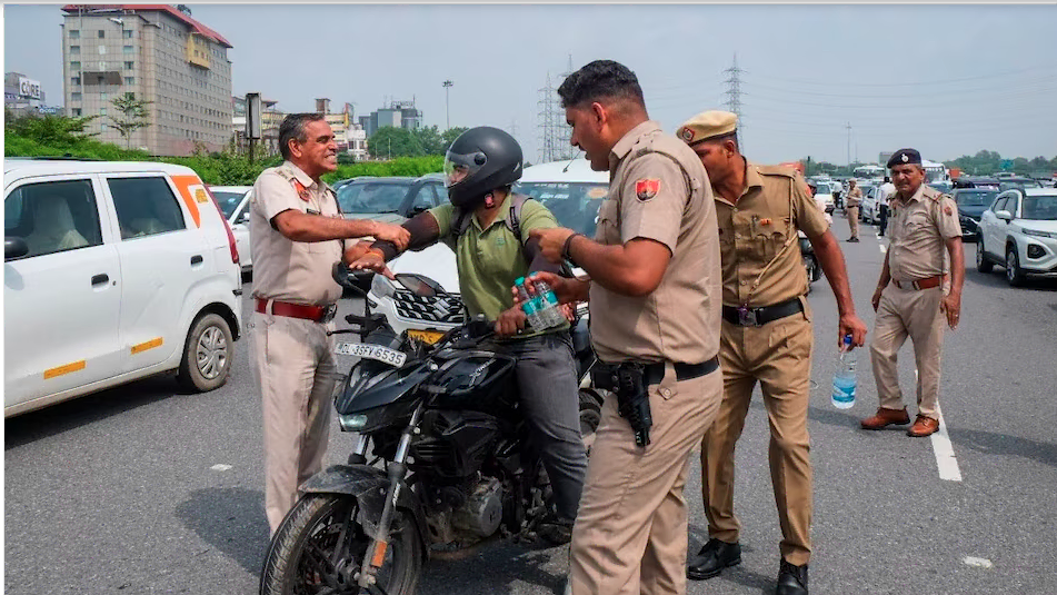Gurugram traffic challan: गुरुग्राम सेक्टर 4/7 चौक पर ट्रैफिक पुलिस द्वारा जब्त की गई बाइक की जांच करते अधिकारी