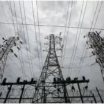 Delhi Electricity Price Hike: Electricity meter and power transmission lines representing hike and increased electricity bills in Delhi.