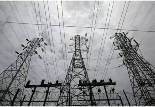 Delhi Electricity Price Hike: Electricity meter and power transmission lines representing hike and increased electricity bills in Delhi.