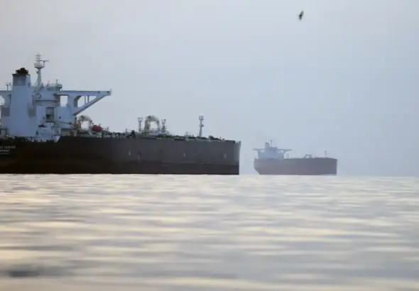 Commercial oil tankers and cargo ships passing through the Hormuz Strait as Oman discusses possible shipping service charges