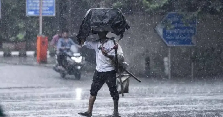Monsoon Alert: Dark monsoon clouds over an Indian city skyline with heavy rainfall, lightning and weather warning conditions during an active monsoon spell.