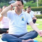 CM Dhami performing yoga with thousands of participants during International Yoga Day 2026 celebrations in Banbasa, Champawat.