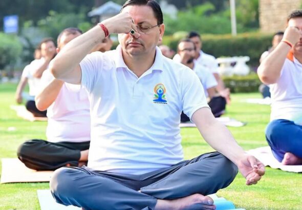CM Dhami performing yoga with thousands of participants during International Yoga Day 2026 celebrations in Banbasa, Champawat.