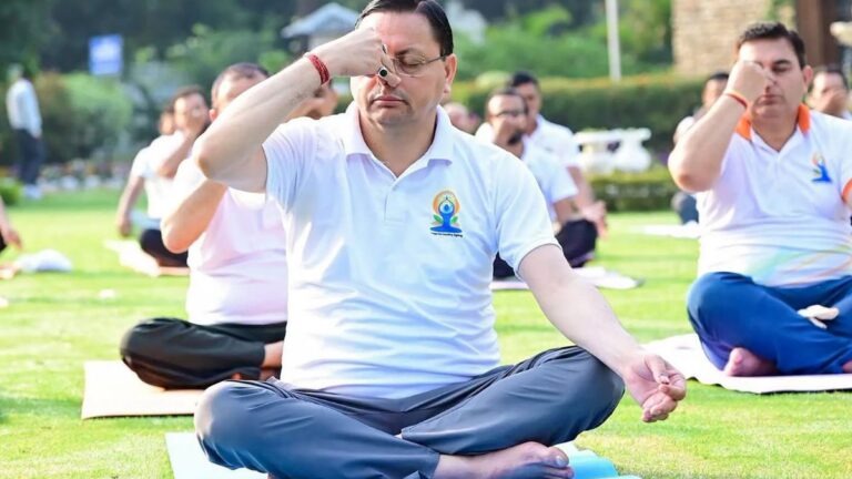 CM Dhami performing yoga with thousands of participants during International Yoga Day 2026 celebrations in Banbasa, Champawat.