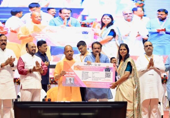 UP CM Yogi Adityanath launching the Teacher Cashless Medical Scheme at an event in Agra with education officials and beneficiaries.